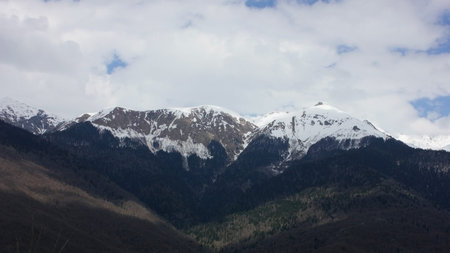 Mountain landscape. Cloudy weather. Snow on mountain peaks in Sochi, Russia.