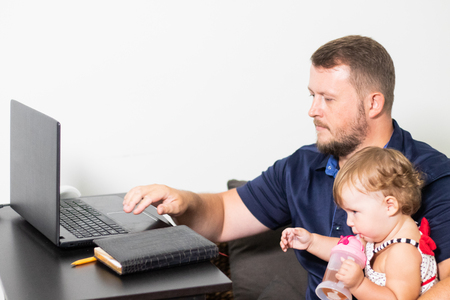 dad freelancer works. child interferes. freelancing problemsの写真素材