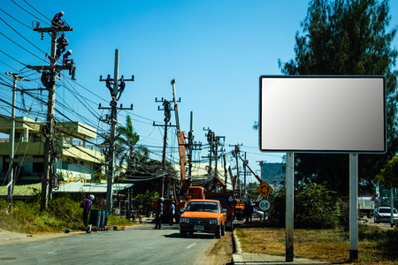 Electricians working on a power pole, filled with complex communication lines. copy space.の写真素材