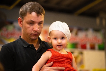 tired dad holding daughter in his arms, fatherhood conceptの写真素材