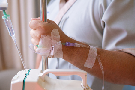 Close-up. Male hand with a dropper during chemotherapy in a hospital. Hand with a dropper. Health is a topic of health and healing.の写真素材