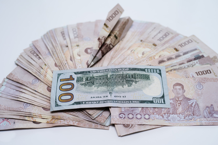 Thai money 1000 baht and 100 dollar, thai bank note background, next to the planeの写真素材