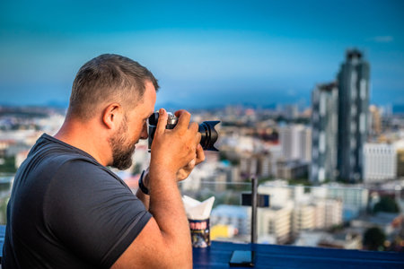 Male photographs on a digital camera panorama of the city of Pattaya, Thailand