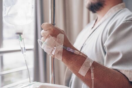 Dropper in a mans hand in a hospital. close-up.の写真素材