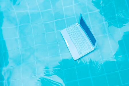 Laptop under water. Minicomputer at the bottom of the pool. The concept of obstruction at work. Blur abstract backgroundの写真素材