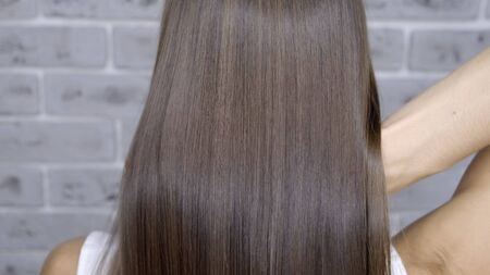 Result after lamination and hair straightening in a beauty salon for a girl with brown hair. hair care concept.の写真素材
