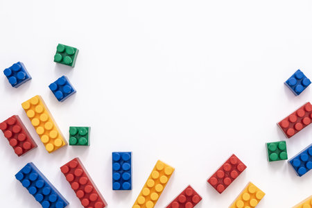 On a white background in a chaotic manner are large multi-colored childrens blocks-designer for the construction of houses and buildings of varying complexity. copy spaceの写真素材