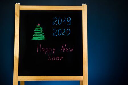 Inscription Happy New Year on black board. Black board with hand inscription Happy New Year with chalk.New Year and Christmas greeting card. New Years conceptの写真素材