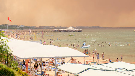 Smoke from forest fires rising over a beach in Antalya, Manavgat resort town of Turkey. View with...