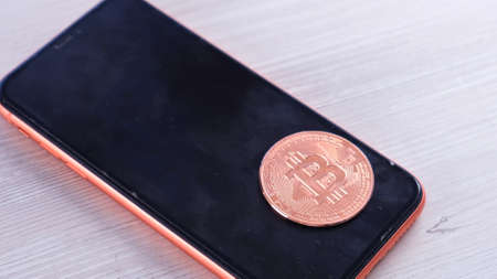 smartphone with bitcoin coin for shopping on a light background. Online shopping concept, blockchain, crypto mining: Moscow, Russia - May 31, 2021のeditorial素材