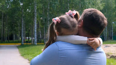 strong Father holds on his arms a sweet daughter, 3 years old, hugs her and hugs her. The concept of parenting, overcoming problems in the relationship between father and daughter, illness, fear for your child.の写真素材