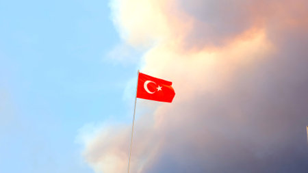 Turkey flag close-up on a background of forest fire smoke clouds. Selective focusの写真素材