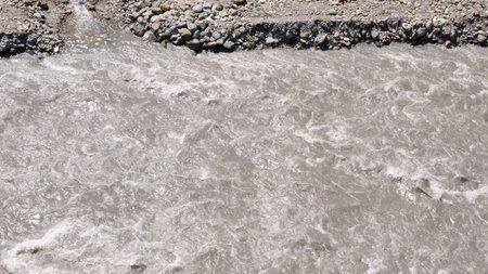 Natural mountain river in Sochi, Russia, close up. A strong and powerful stream of water is the silv...