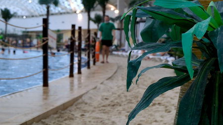 Indoors a luxurious indoor swimming pool with blue water and real golden sand. The concept of summer vacations and recreation, travel, swimming training: Sochi, Russia - May 17, 2021.のeditorial素材