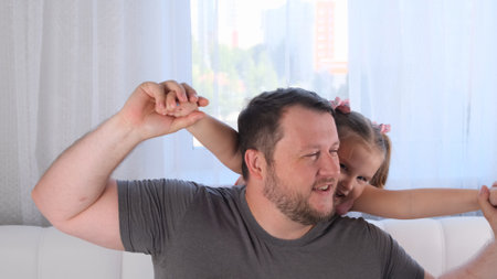 laughing Little daughter 3 years old and father gently hug and have fun at home. have fun with your baby, fool concept. fathers day. parenting, relationships between children and parents.の写真素材