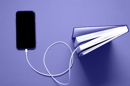 smartphone connects to the old book with a cable and downloads information from there. Electronic information. Very Pure tone imageの写真素材
