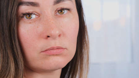 Close up portrait of indignant frowning sad brunette woman. The concept of problems, resentment, unpleasant situation.の写真素材