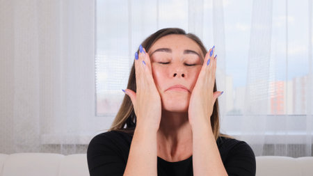 brunette woman doing facial massage along massage lines and points with her hands. Hygiene, beautician, make up, facial skin massage. Facial gymnastics. System of exercises improve skin yourself.の写真素材