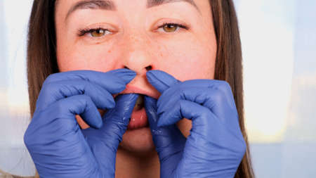 Intra oral neuromuscular massage. Female professional beautician makes facial massage to herself, close up.の写真素材