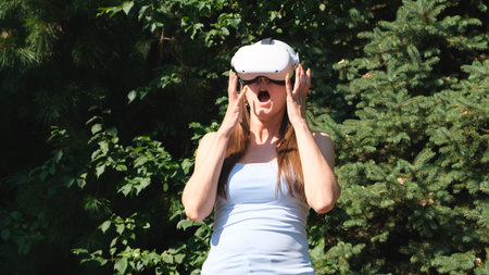 scared female in virtual reality glasses screams in horror from the fear of what he saw on the...