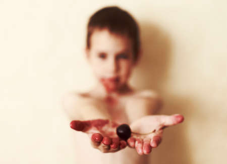 stained child. child stained cherry juice with berries in handsの写真素材
