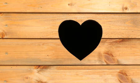 heart on the door. a hole in the shape of a heart on a wooden backgroundの写真素材