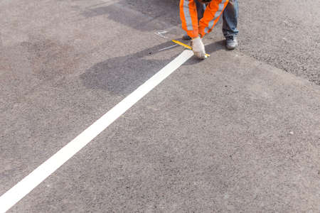 road line. worker painted on the asphalt road markingの写真素材