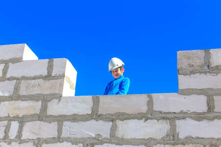 boy on a building site. boy playing in a helmet on a construction siteの写真素材