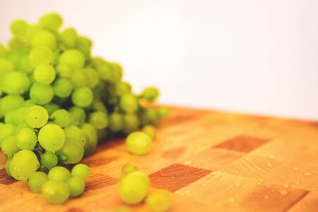 Fresh green grape on the wooden cutting boardの写真素材