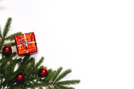 Christmas gift box and holiday decor with fir tree brunch and red balls. New year decoration background on the artificial snow, flat lay, top view, horizontal, copy spaceの写真素材