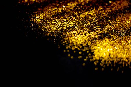 golden glitter sparkle on black background. Isolated. Flat lay. Christmas background. New year decoration. wallpaper. Copy spaceの写真素材