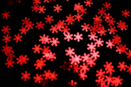 red snowflake glitter sparkle on black background. Isolated. Flat lay. Christmas background. New year decoration. wallpaper. Copy space. blurの写真素材