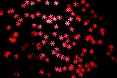red snowflake glitter sparkle isolated on black backgroundの写真素材