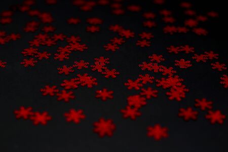 red snowflake glitter sparkle on black background. Isolated. Flat lay. Christmas background. New year decoration. wallpaper. Copy spaceの写真素材