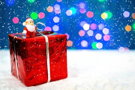 Christmas holiday decor with Santa Claus and gift. New year decoration background on the artificial snow, flat lay, top view, horizontal, copy space. Snowingの写真素材