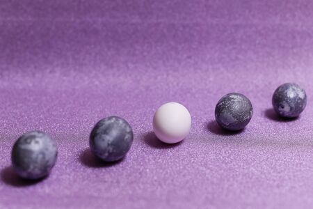 Eggs with marble stone effect painted with natural dye carcade flower on lilac sparkling backgroundの写真素材