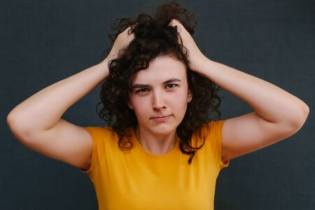 Portrait of funny emotional curly girl on grey background. Surprise. Upset. Joy. Fright. Happy. Sadness. Copy spaceの写真素材