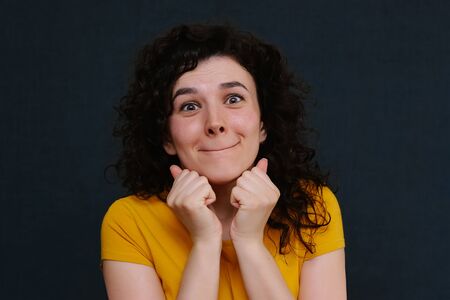 Portrait of funny emotional curly girl on grey background. Surprise. Joy. Happy.の写真素材