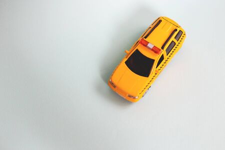 Yellow toy taxi car model. idea, symbol, concept of urban service and delivery. Copy space. Mobile online application concept.の写真素材