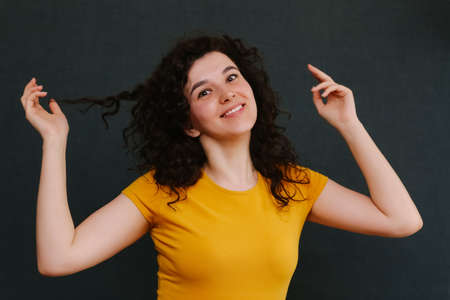 Portrait of funny emotional curly girl on grey background. Surprise. Upset. Joy. Fright. Happy. Sadness. Copy spaceの写真素材