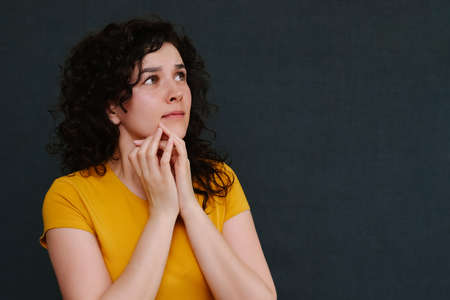 Portrait of scared emotional girl on grey background. Upset.の写真素材