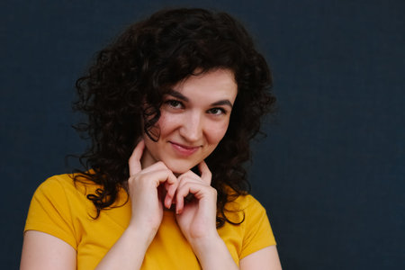 Portrait of young cute emotional caucasian female on grey background.