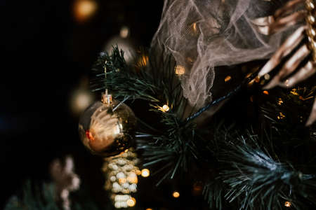 Blurred picture of christmas tree with lights and spruce branch. Defocused new year background with space for textの写真素材
