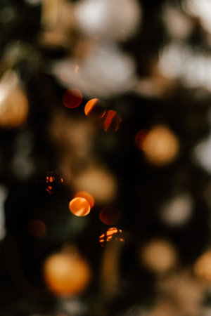 Blurred picture of christmas tree with lights and spruce branch. Defocused new year background with...