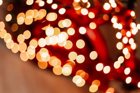 Blurred picture of christmas tree with lights and spruce branch. Defocused new year background with space for textの写真素材