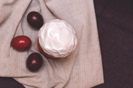 Easter pastries and colored eggs on a textile background. Traditional pastries for Orthodox...