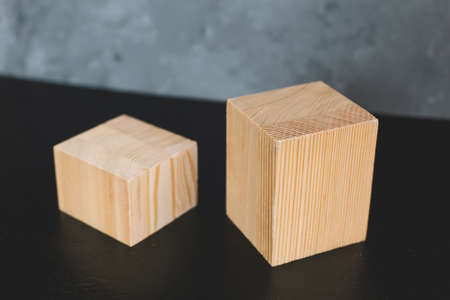 Natural mockup of wooden cubes for cosmetics on black and grey background.の写真素材