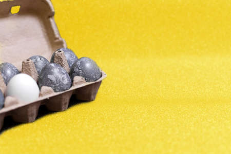 Easter card. Eggs with marble stone effect painted with natural dye carcade flower on yellow sparkling background with blank space for text. Top view. Flat lay. Color of the yearの写真素材