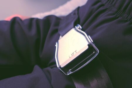 Childs hands fasten safety seat belt on the planeの写真素材