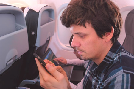 Father and son in gadgets on Board the plane during the flight